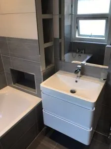 Bathroom Renovation with Wetroom project featuring a new walk-in shower, retained bath, wall-hung basin unit