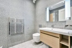 Bathroom renovation in Kensington with textured grey tiles.